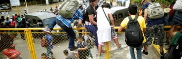 Cientos de personas de la caravana que salió a pie desde Honduras rumbo a EE.UU. saltan la frontera hacia México entre fuertes tensiones